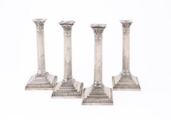 A SET OF FOUR ELECTRO-PLATED CORINTHIAN CANDLESTICKS