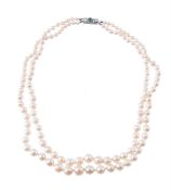 A TWO STRAND CULTURED PEARL NECKLACE TO A DIAMOND AND EMERALD CLASP