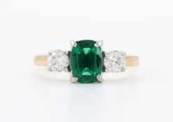 A SYNTHETIC EMERALD AND DIAMOND THREE STONE RING