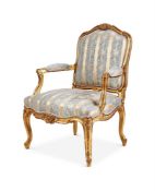 A CARVED GILTWOOD AND UPHOLSTERED FAUTEUIL IN LOUIS XV STYLE, CIRCA 1870