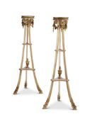 A PAIR OF GEORGE III CREAM PAINTED AND PARCEL GILT TRIPOD TORCHERES BY GILLOWS