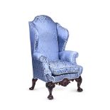 A MAHOGANY AND BLUE DAMASK UPHOLSTERED WING ARMCHAIR IN GEORGE II STYLE, LATE 19TH OR EARLY 20TH