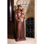 A LARGE CARVED AND STAINED WOOD FIGURE OF A SAINT HOLDING AN INFANT, SECOND HALF 20TH CENTURY