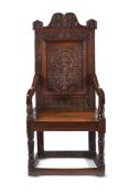 A CARVED OAK PANEL BACK ARMCHAIR IN 17TH CENTURY STYLE