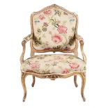 A CARVED GILTWOOD AND TAPESTRY UPHOLSTERED FAUTEUIL IN LOUIS XV STYLE