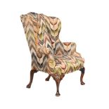 A WALNUT AND UPHOLSTERED WING ARMCHAIR, IN GEORGE II STYLE