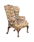 A WALNUT AND UPHOLSTERED WING ARMCHAIR, IN GEORGE II STYLE