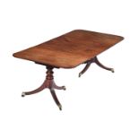 A MAHOGANY TWIN-PEDESTAL EXTENDING DINING TABLE