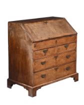 A GEORGE II WALNUT AND CROSS BANDED BUREAU