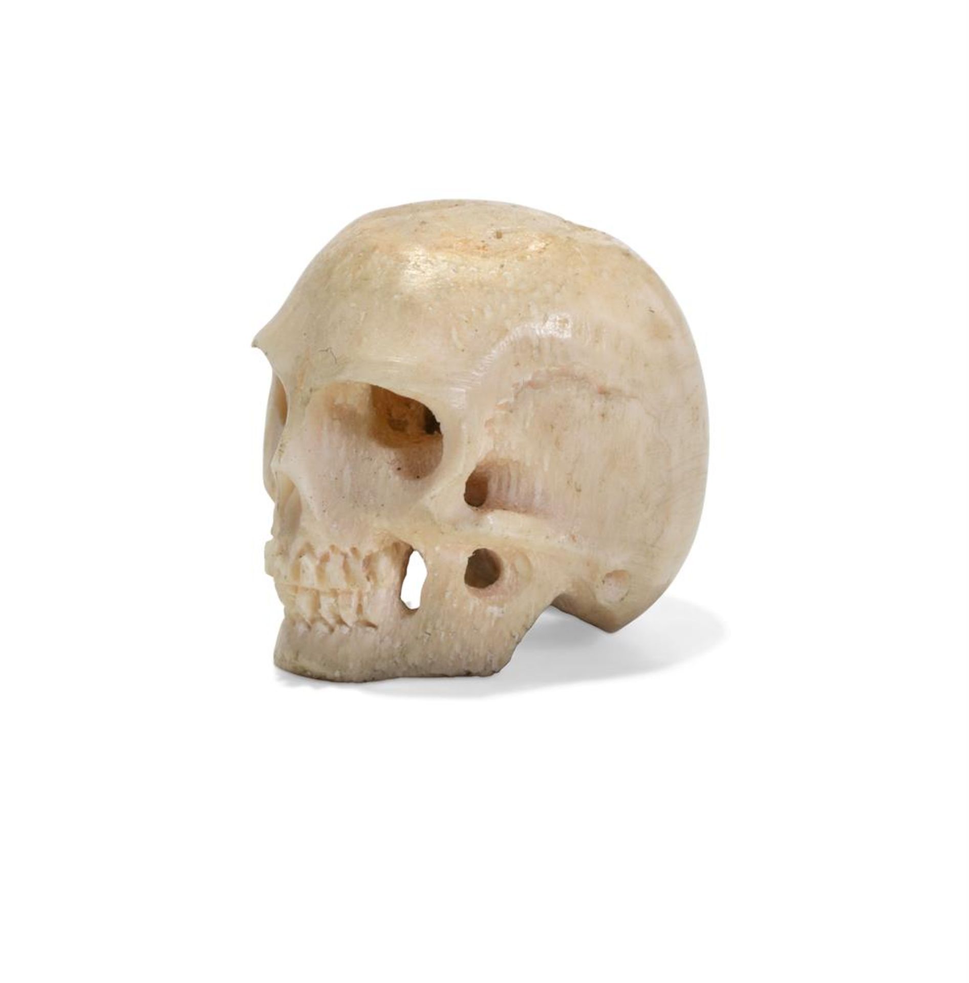 A TINY CARVED BONE MODEL OF A SKULL, PROBABLY JAPANESE OR ITALIAN