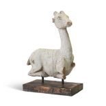 A WHITE PAINTED CARVED WOOD MODEL OF A CROUCHING DEER OR WHITE HART, PROBABLY INDIAN OR EGYPTIAN