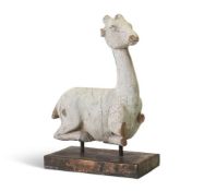 A WHITE PAINTED CARVED WOOD MODEL OF A CROUCHING DEER OR WHITE HART, PROBABLY INDIAN OR EGYPTIAN
