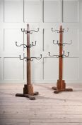A CLOSELY MATCHED PAIR OF OAK, WROUGHT IRON AND BRASS HAT AND COAT STANDS, EARLY 20TH CENTURY
