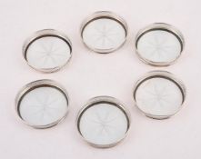 A SET OF SIX AMERICAN SILVER COLOURED MOUNTED GLASS COASTERS