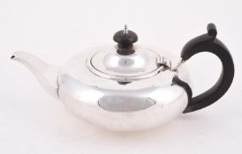 AN EDWARDIAN SILVER CIRCULAR COMPRESSED TEA POT