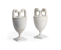 A PAIR OF CARVED WHITE MARBLE TWIN HANDLED NEOCLASSICAL PEDESTAL URNS, 19TH OR EARLY 20TH CENTURY