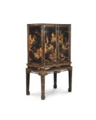 A CHINESE EXPORT BLACK LACQUER AND GILT CHINOISERIE DECORATED CABINET ON STAND