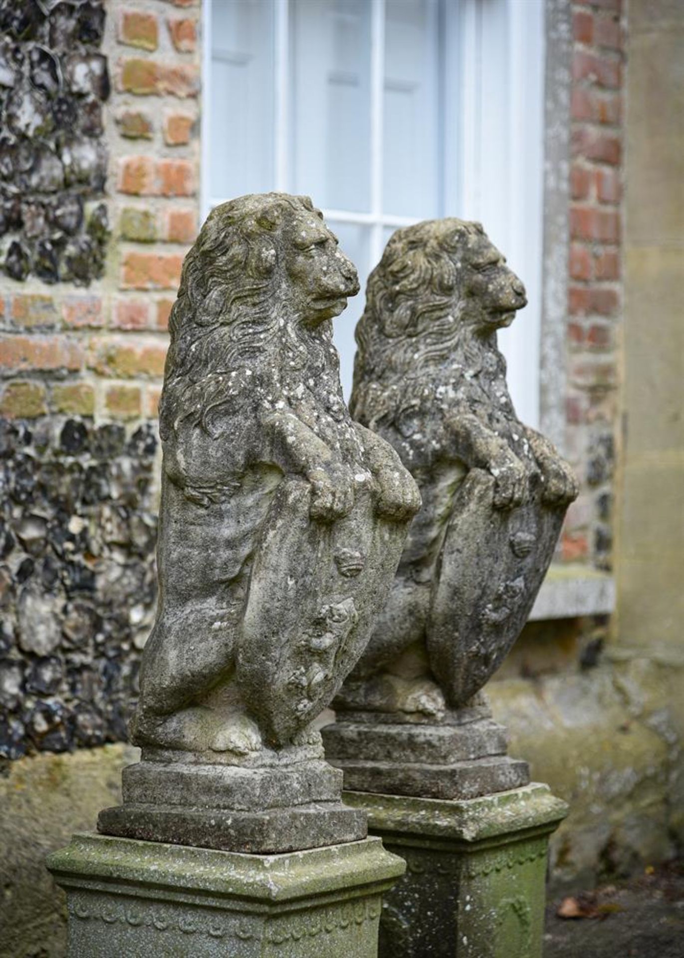 A PAIR OF COMPOSITION STONE HERALDIC LIONS, 20TH CENTURY
