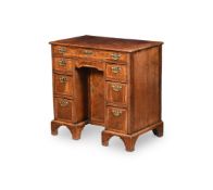 A GEORGE I WALNUT AND CROSSBANDED KNEEHOLE DESK, CIRCA 1725