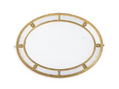 A GEORGE III OVAL GILTWOOD MIRROR, IN THE MANNER OF ROBERT ADAM, CIRCA 1780