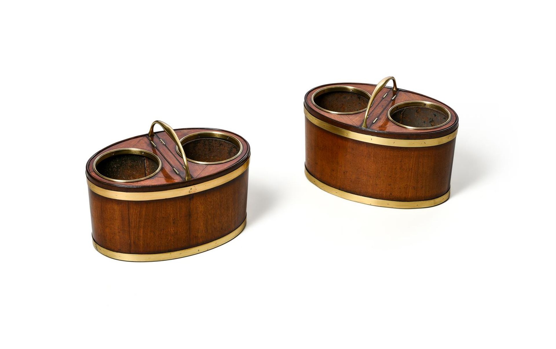 A RARE PAIR OF GEORGE III BRASS MOUNTED MAHOGANY TABLE TOP OVAL WINE COOLERS, CIRCA 1790
