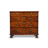 A QUEEN ANNE WALNUT AND FEATHER BANDED CHEST OF DRAWERS, CIRCA 1710