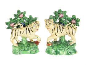 A PAIR OF STAFFORDSHIRE CREAMWARE/PEARLWARE BOCAGE MODELS OF TIGERS SECOND QUARTER 19TH CENTURY Mo