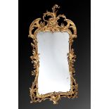 A CARVED GILTWOOD WALL MIRROR, IN IRISH GEORGE II STYLE