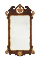 A GEORGE II WALNUT AND PARCEL GILT WALL MIRROR