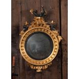 A REGENCY GILTWOOD CONVEX WALL MIRROR, CIRCA 1820