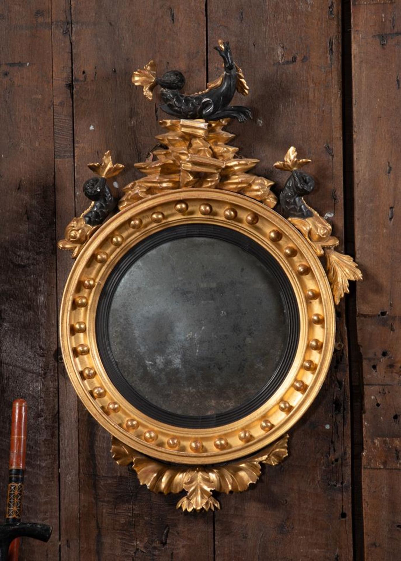 A REGENCY GILTWOOD CONVEX WALL MIRROR, CIRCA 1820