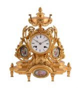 A FRENCH GILT METAL MANTEL CLOCK WITH PORCELAIN PANELS