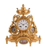 A FRENCH GILT METAL MANTEL CLOCK WITH PORCELAIN PANELS