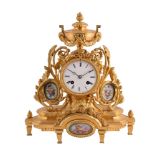 A FRENCH GILT METAL MANTEL CLOCK WITH PORCELAIN PANELS