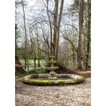 A STONE COMPOSITION POND SURROUND AND TRIPLE TIERED FOUNTAIN, ATTRIBUTED TO AUSTIN AND SEELEY