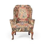 A WALNUT AND NEEDLEWORK UPHOLSTERED WING ARMCHAIR