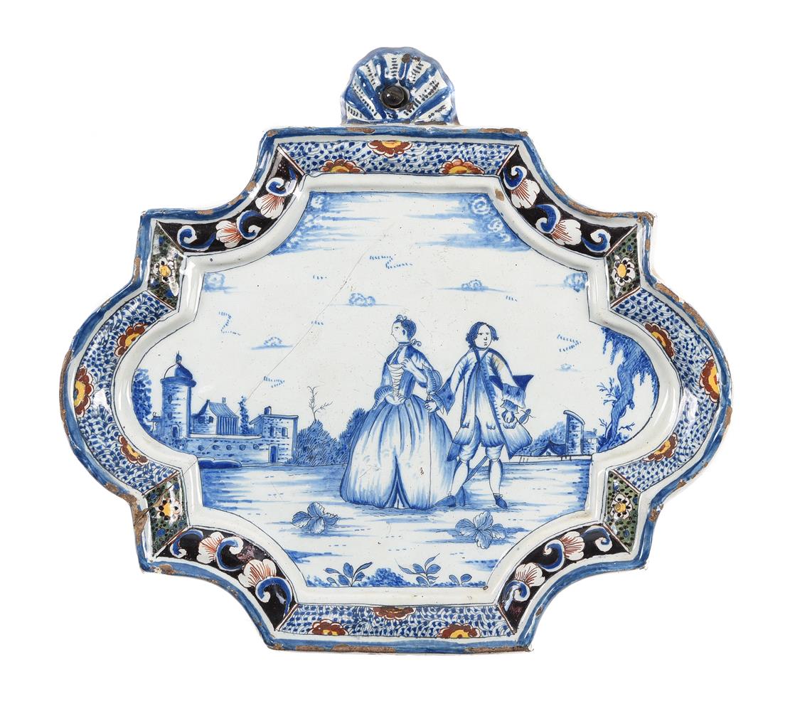 A DUTCH DELFT SHAPED RECTANGULAR BLUE AND WHITE WALL PLAQUE WITHIN A POLYCHROME BORDER