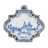 A DUTCH DELFT SHAPED RECTANGULAR BLUE AND WHITE WALL PLAQUE WITHIN A POLYCHROME BORDER
