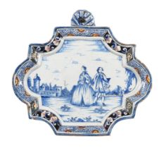 A DUTCH DELFT SHAPED RECTANGULAR BLUE AND WHITE WALL PLAQUE WITHIN A POLYCHROME BORDER
