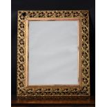 A CARVED GILTWOOD WALL MIRROR