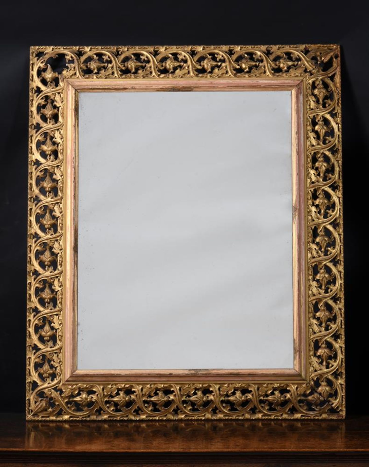 A CARVED GILTWOOD WALL MIRROR