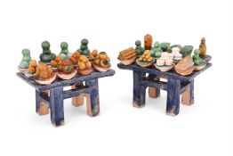 A pair of chinese sancai-glazed tables with dishes of fruit and breads and pouring vessels