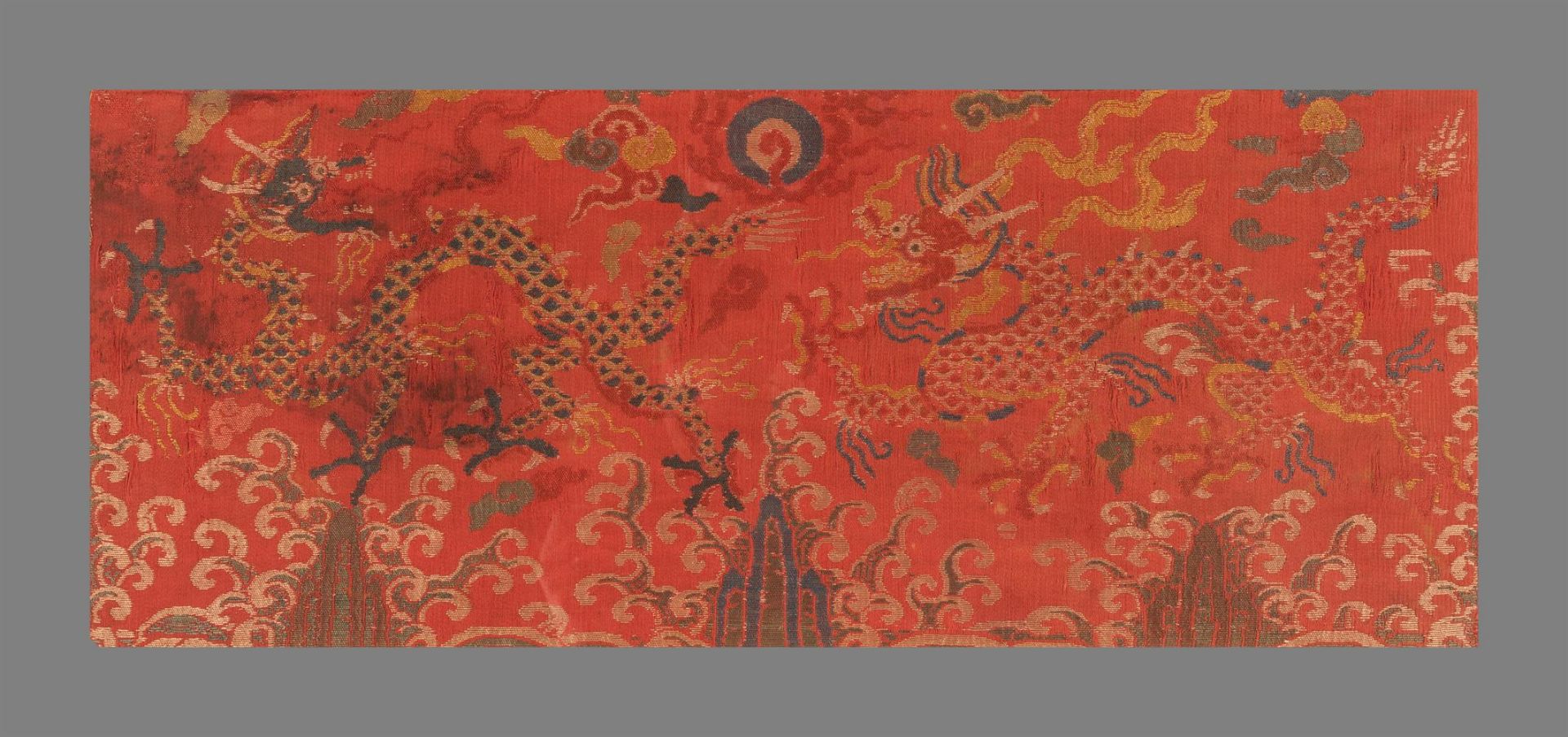 A Chinese red ground silk brocade 'Dragon' panel