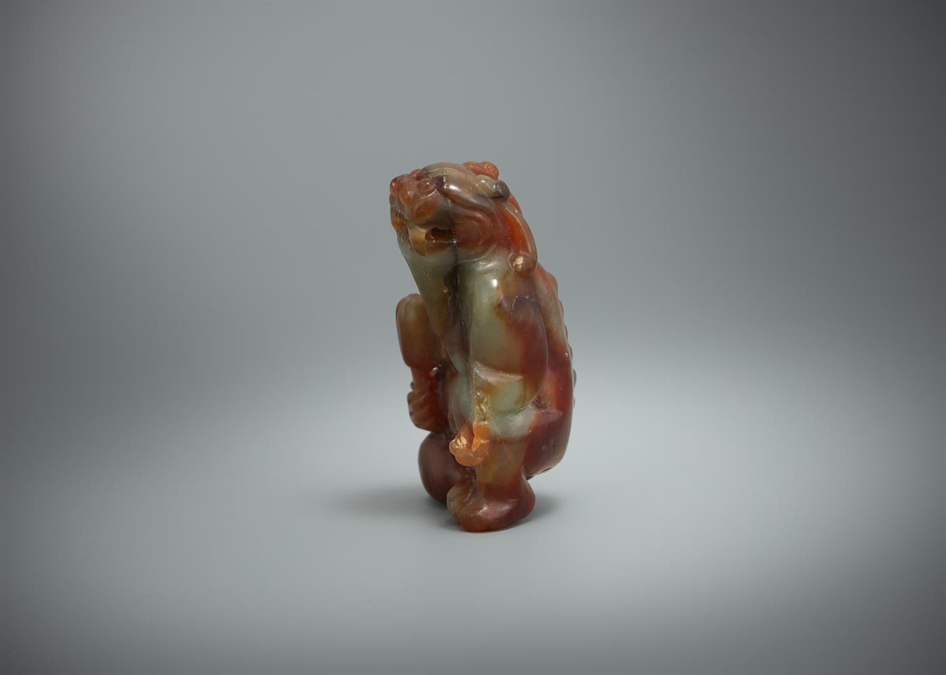 A Chinese mottled jade model of a seated mythical beast