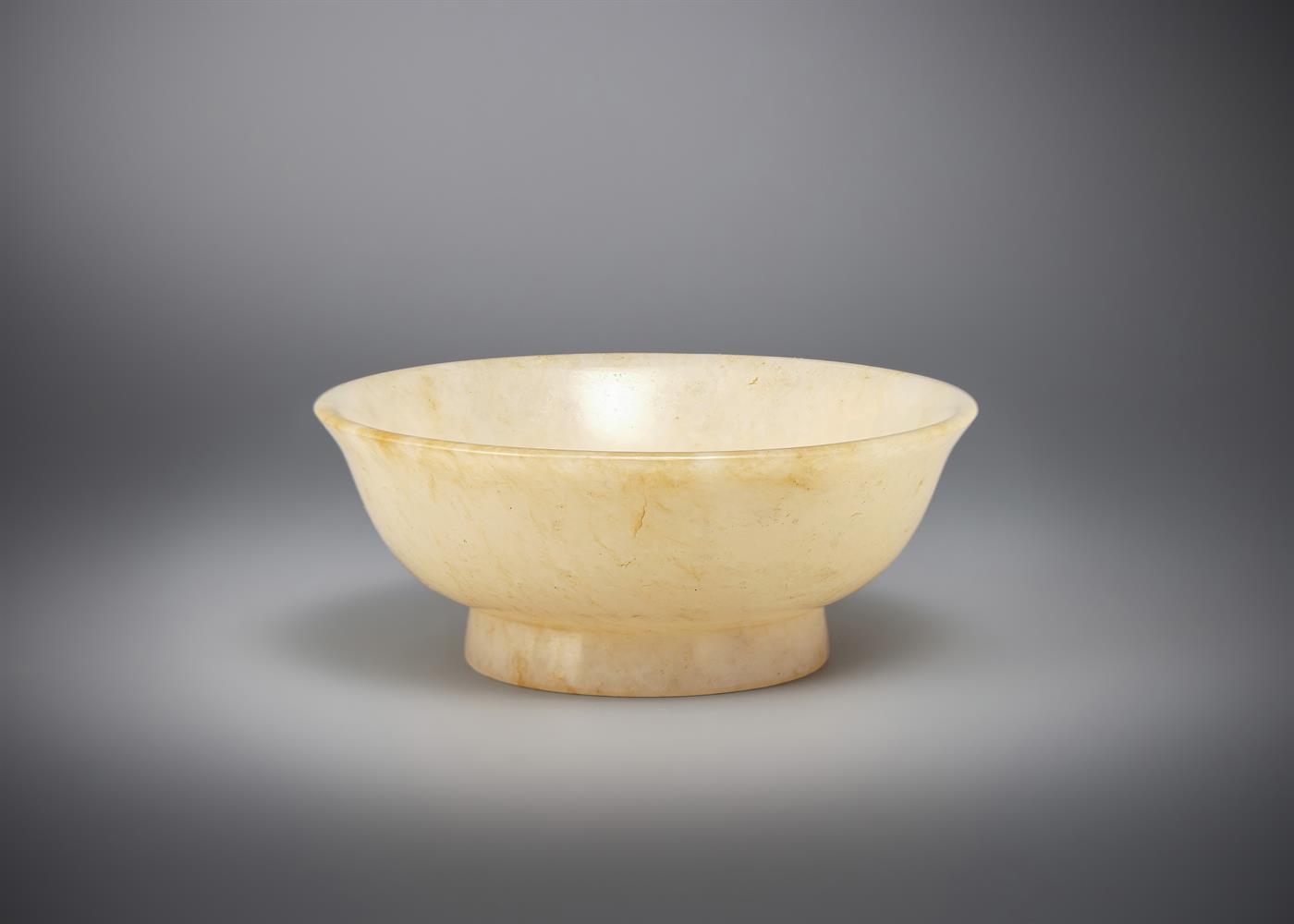 A Chinese small pale celadon and russet jade bowl