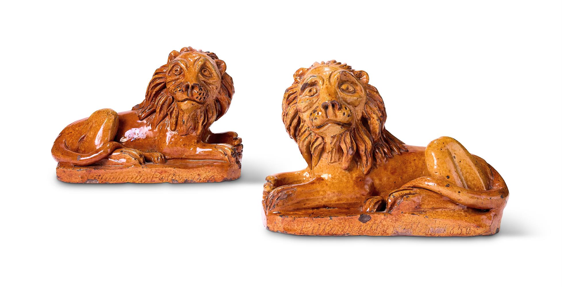 A PAIR OF PILL POTTERY (NEWPORT MONMOUTHSHIRE) TREACLE-GLAZED RED POTTERY MODELS OF RECUMBENT LIONS