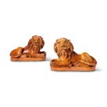 A PAIR OF PILL POTTERY (NEWPORT MONMOUTHSHIRE) TREACLE-GLAZED RED POTTERY MODELS OF RECUMBENT LIONS