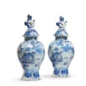 A PAIR OF DUTCH DELFT (DE PORCELEYNE BIJL) BLUE AND WHITE VASES AND COVERS WITH LION FINIALS