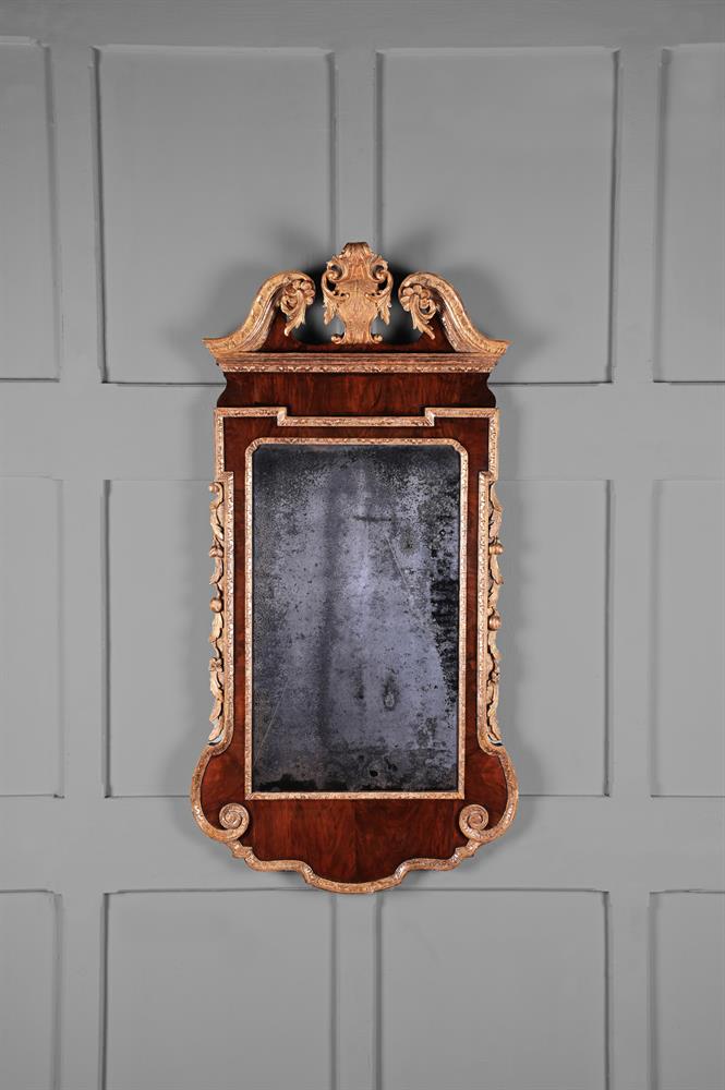 A GEORGE II FIGURED WALNUT AND PARCEL GILT MIRROR, CIRCA 1745