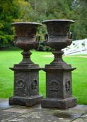 A PAIR OF CAST IRON URNS ON PEDESTALS, AFTER THE HANDYSIDE PATTERN, IN VICTORIAN STYLE, 20TH CENTURY